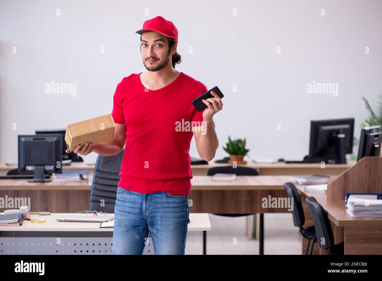 Young courier delivering post to the office Stock Photo Alamy