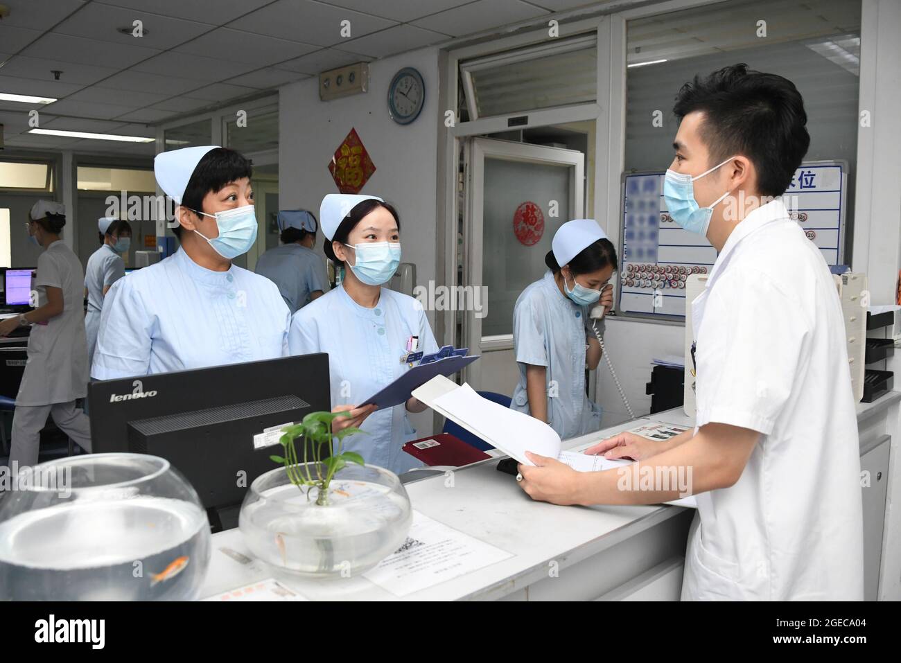 (210819) -- BEIJING, Aug. 19, 2021 (Xinhua) -- Ma Yuan (R) learns about patients' conditions from nurses at Haidian Hospital in Beijing, capital of China, Aug. 12, 2021. Ma Yuan, 28, is a resident orthopedic doctor at Haidian Hospital in Beijing. During working hours, Ma needs to attend morning shift meetings, follow superior doctors to make the rounds of the wards, participate in surgeries and etc. Sometimes Ma has to work continuously for up to 36 hours. Although the workflow is the same almost every day, there are different challenges in clinical work. As a young doctor, Ma often deals w Stock Photo