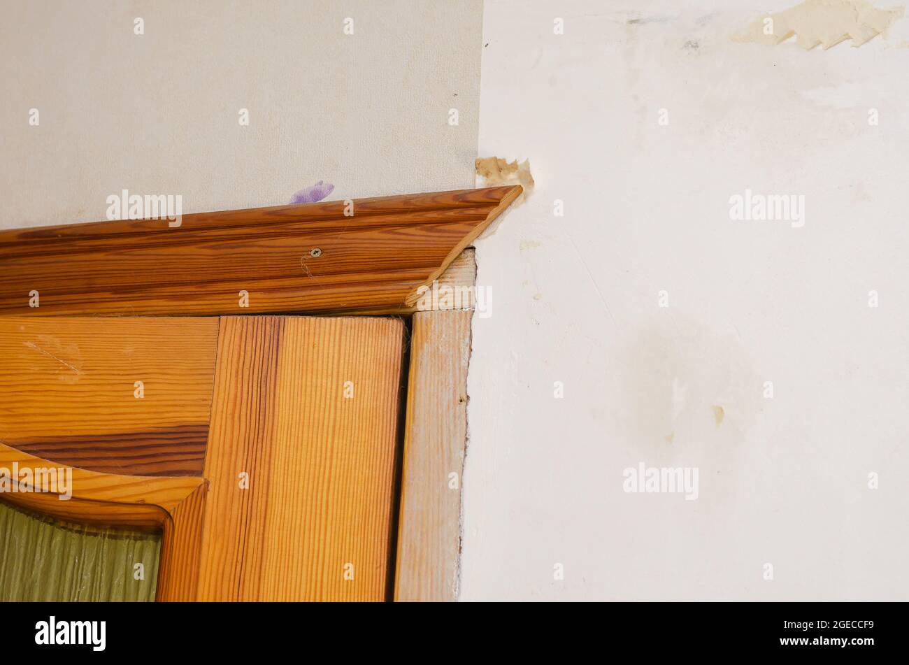 A wall with remnants of paper wallpaper. Vertical wall of the living