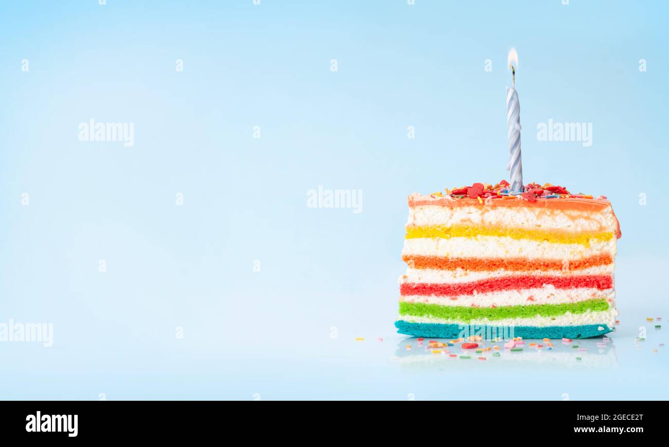 Birthday cake with burning candle on a blue background with copy space ...