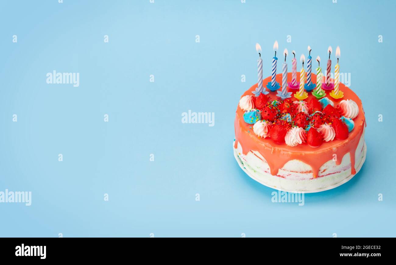 Birthday cake with burning candles on a blue background with copy space ...