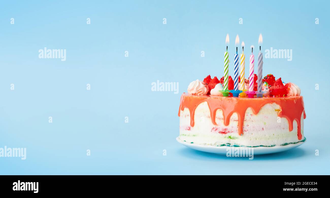 Birthday cake with burning candles on a blue background with copy space ...