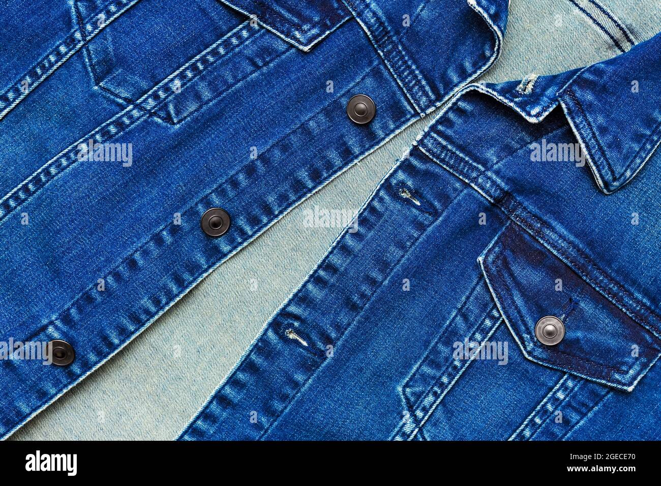 Close up view of denim jacket with buttons and pockets. Blue denim