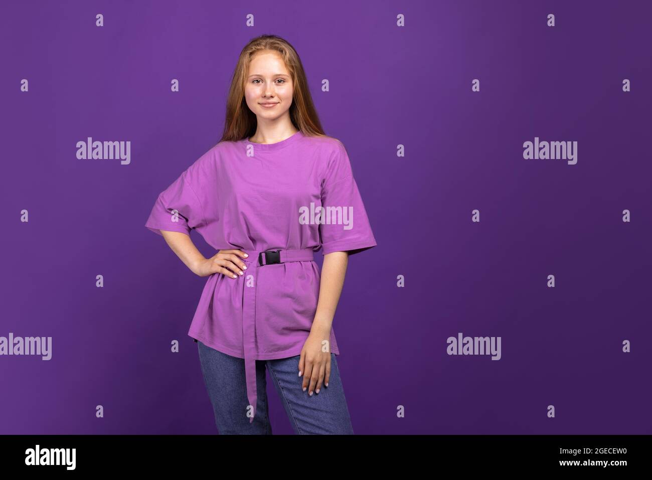 Half-length portrait of young beautiful girl isolated on purple studio background. Concept of human emotions, facial expression, youth, sales, ad. Stock Photo