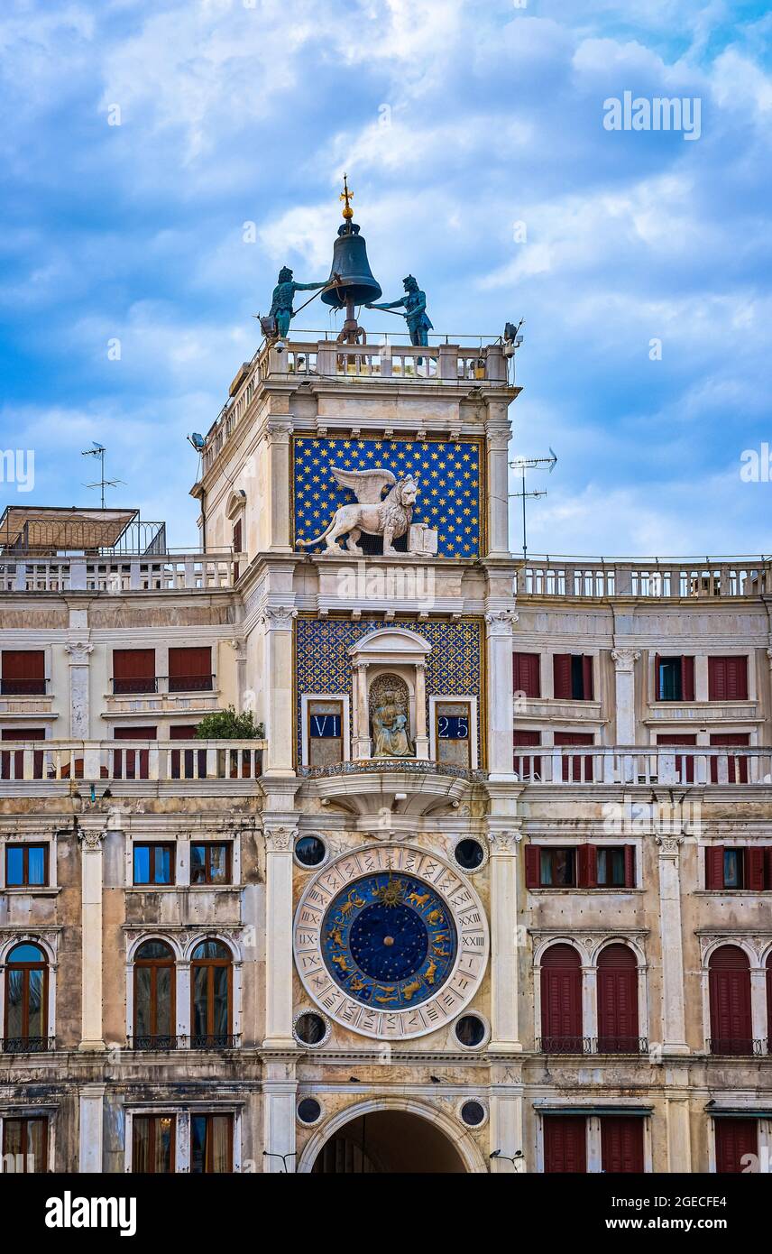Torre dell'Orologio or Clock Tower on St Mark square, Venice, Italy. Moors, Lion, Virgin Mary statues, medieval clock, blue sky, clouds Vertical shot Stock Photo
