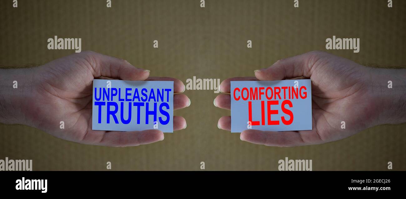 unpleasant truths versus conforting lies on cardboards in man's hands, Concept for different choices in life, people preferring conforting lies above Stock Photo