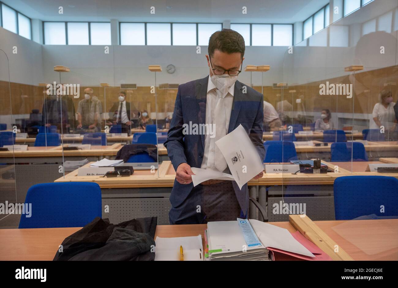 Trier, Germany. 19th Aug, 2021. Senior public prosecutor Eric Samel stands in the courtroom of Trier Regional Court before the trial and looks through documents. The defendant is alleged to have raced through Trier's pedestrian zone in his SUV on December 1, 2020, with the aim of killing or injuring as many people as possible. The prosecution accuses him of five counts of murder and 18 counts of attempted murder. Credit: Harald Tittel/dpa - ATTENTION: Parts of the process documents pixelated for legal reasons/dpa/Alamy Live News Stock Photo