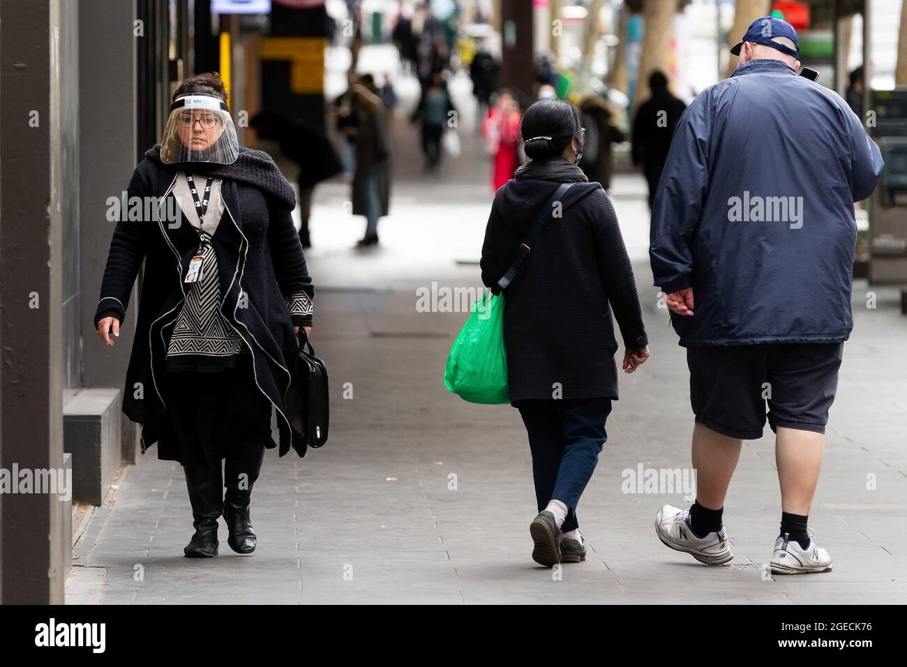 Melbourne, Australia, 23 July, 2020. A woman is seen walking in the CBD as she wears a full face shield in Melbourne as the Victorian Premier confirmed 403 new coronavirus cases overnight. As of 11.59pm on Wednesday 22 July, people living in metropolitan Melbourne and Mitchell Shire and will now be required to wear a face covering when leaving home, following a concerning increase in coronavirus cases in recent days. The fine for not wearing a face covering will be $200. Credit: Dave Hewison/Speed Media/Alamy Live News Stock Photo