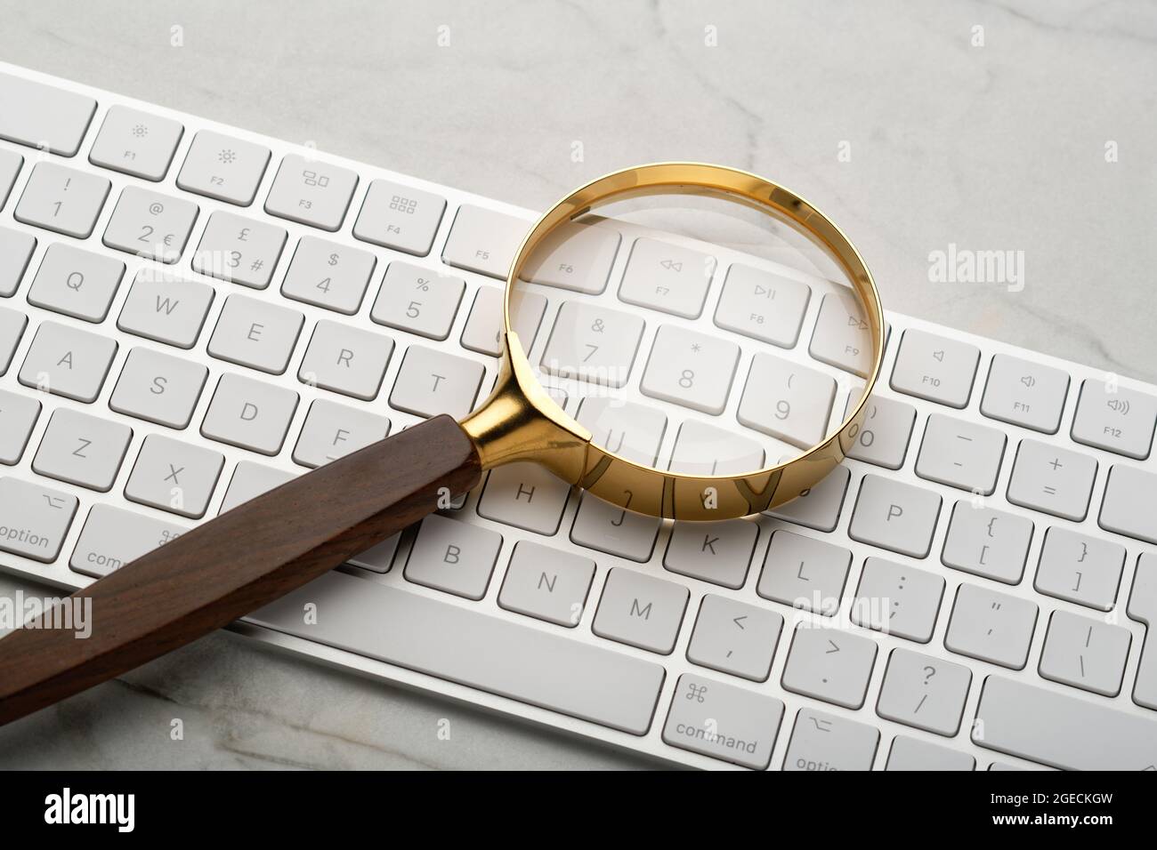 Magnifying glass on a computer keyboard. Illustrating a search of the internet. Finding things by use of a computer. Stock Photo