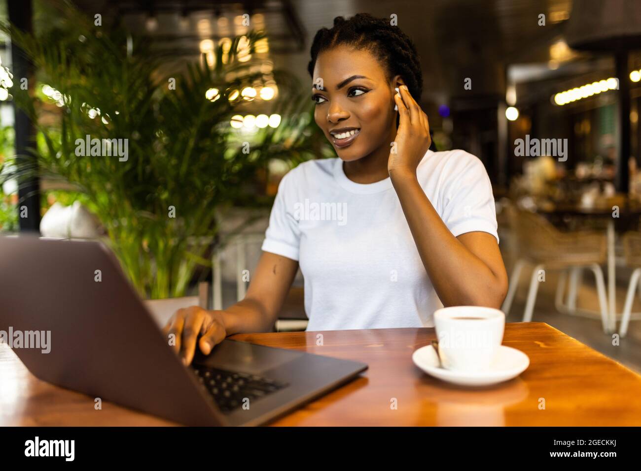 Happy black girl in wireless headphones studying online, using laptop ...