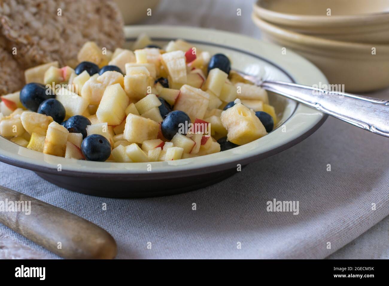 Fruit salad with puffed brown rice cakes on plate. Healthy carbohydrate snack or breakfast Stock Photo