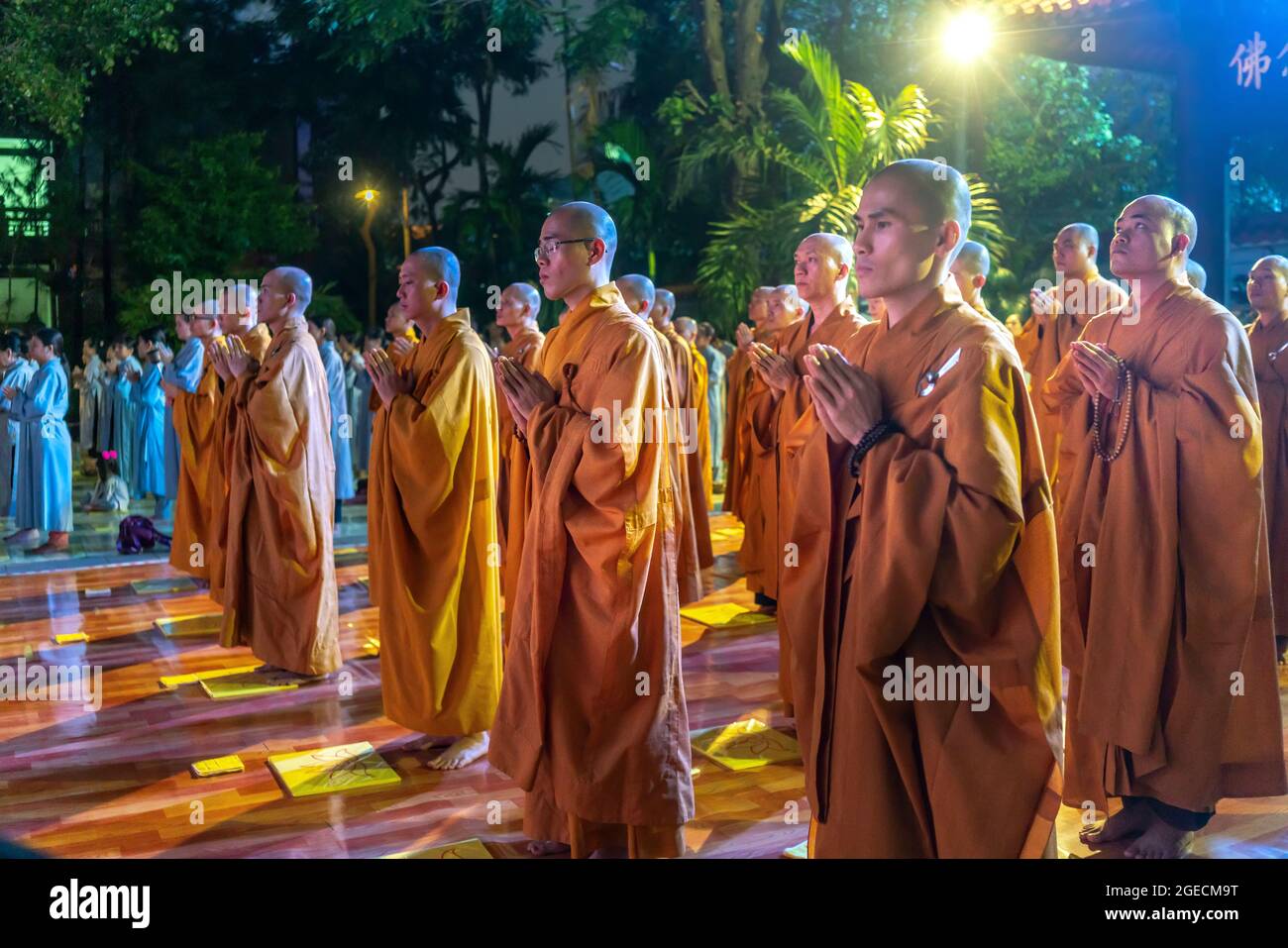 Monks are chanting prayers for peace during annual Amitabha Buddha ceremony held in evening at an ancient temple in Ho Chi Minh City, Vietnam Stock Photo