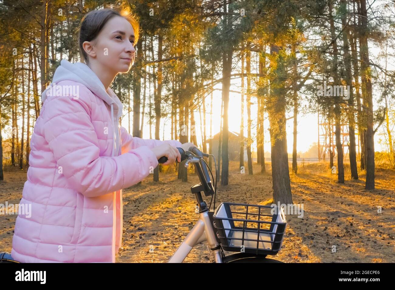 Young woman walking with bicycle in autumn city park Stock Photo