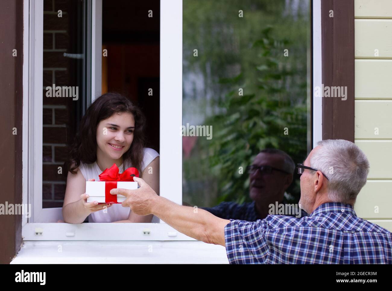 grandfather gives granddaughter a gift Stock Photo Alamy