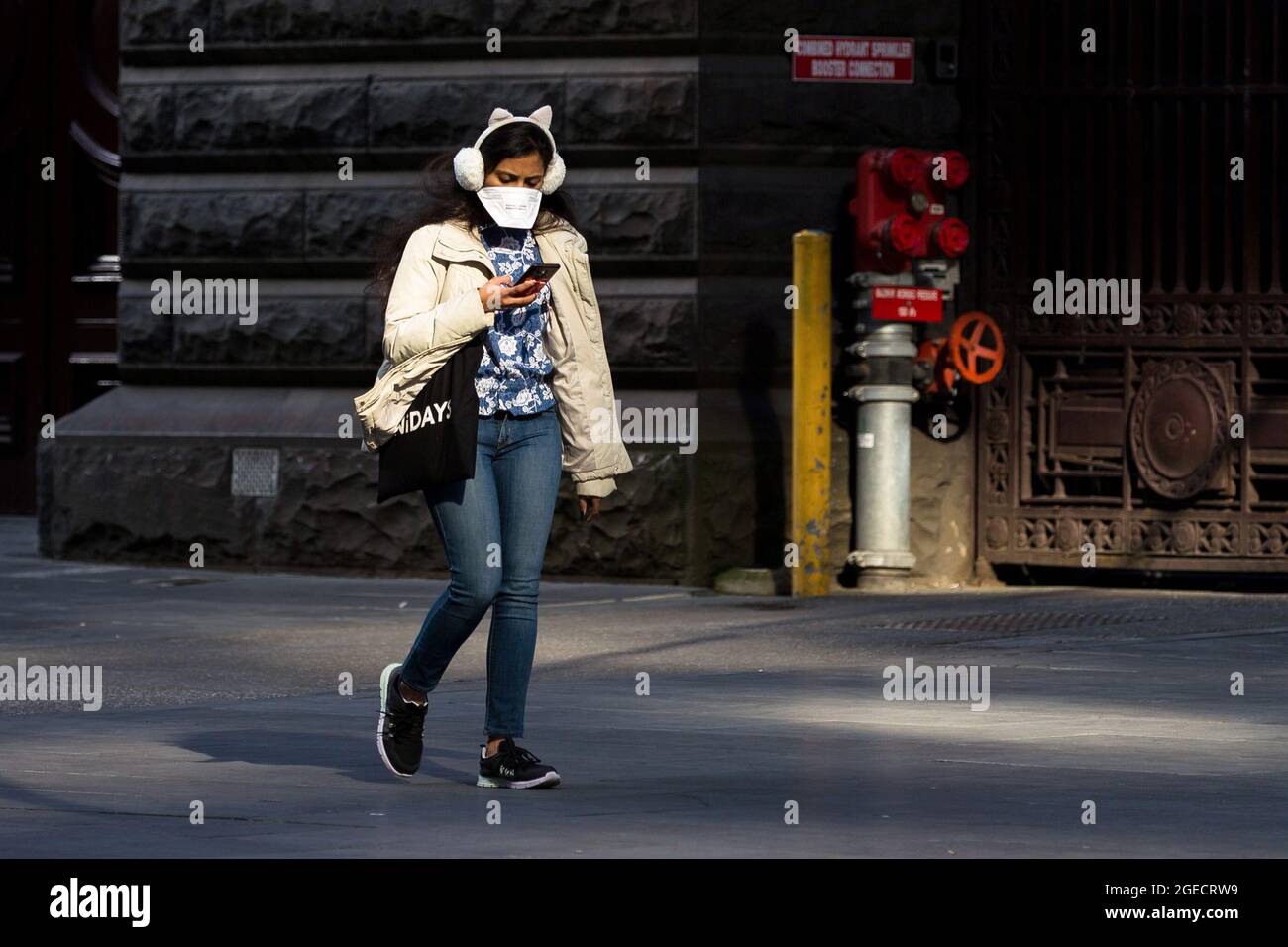 Melbourne, Australia, 25 August, 2020. A woman wearing an oversize mask and feline ear muffs walks through the CBD. (Photo by Dave Hewison/Speed Media) Credit: Dave Hewison/Speed Media/Alamy Live News Stock Photo