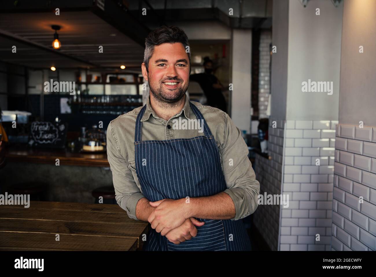 Smiling cafe owner in apron hi-res stock photography and images - Alamy