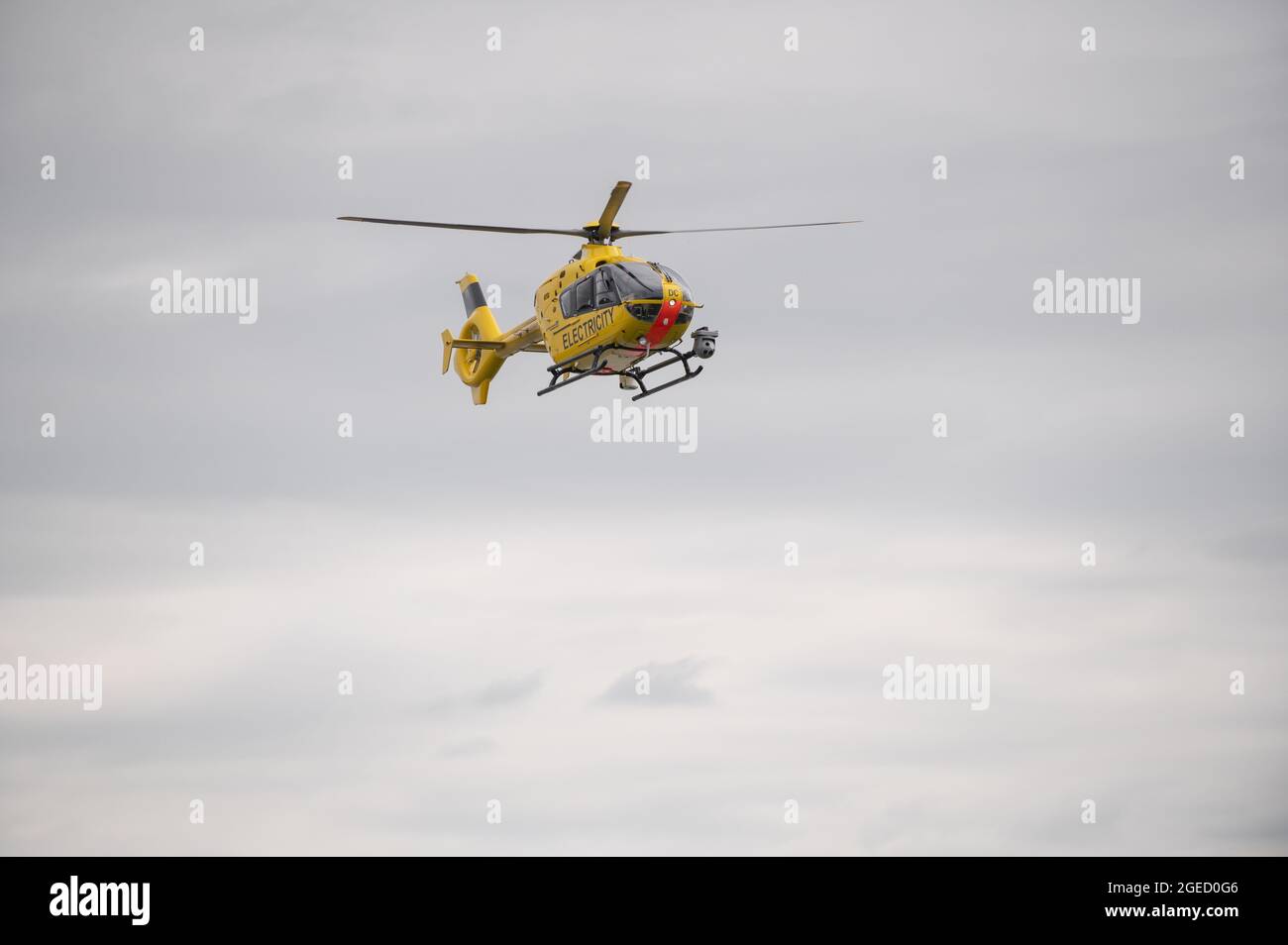 A helicopter run by the UK's National Grid electricity supply making routine inspections over Warwickshire, UK. Stock Photo