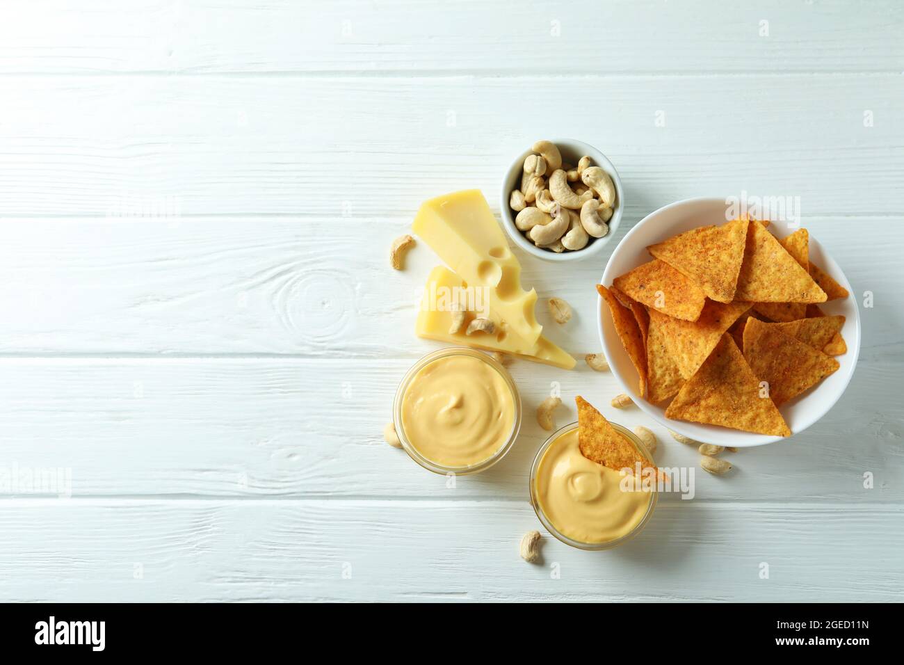 Snacks with cheese sauce on white wooden table Stock Photo - Alamy