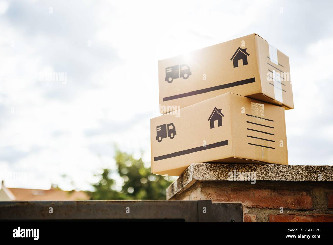 Package and delivery boxes on the entrance wall of a particular house - - Small business, shopping online and delivery service concept Stock Photo