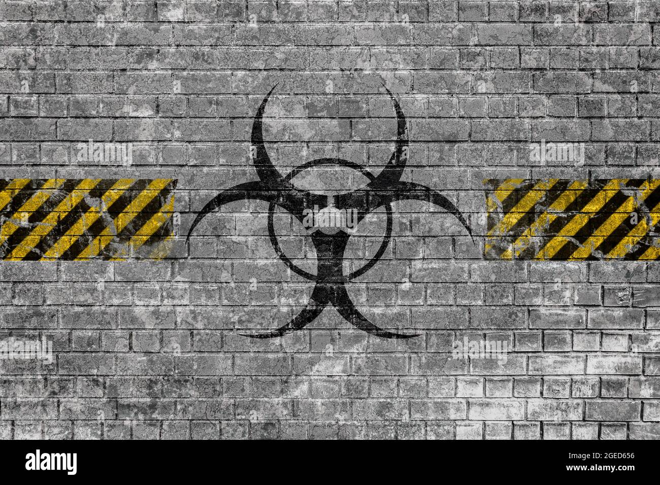 Faded biohazard sign with yellow-black lines on old brick wall with ...