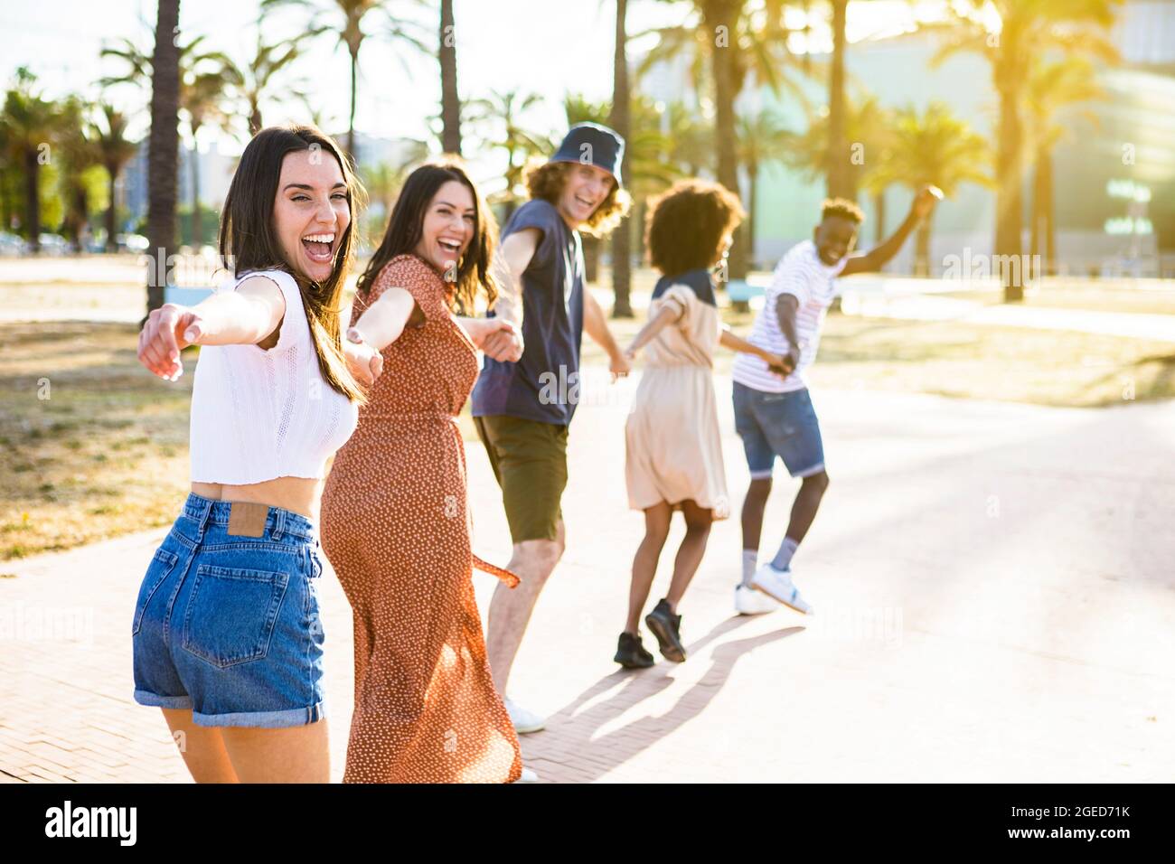 Multiethnic group of young friends running happily together  Stock Photo