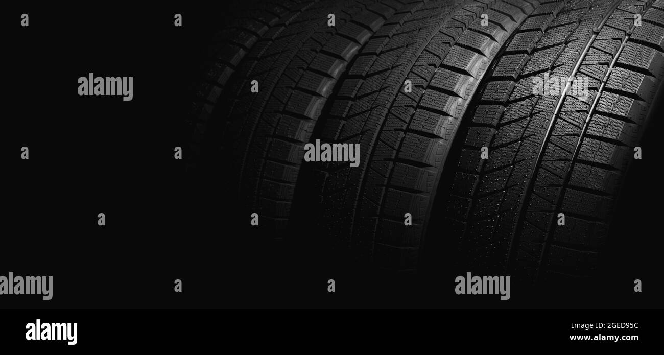 new winter car tires on black background. copy space Stock Photo