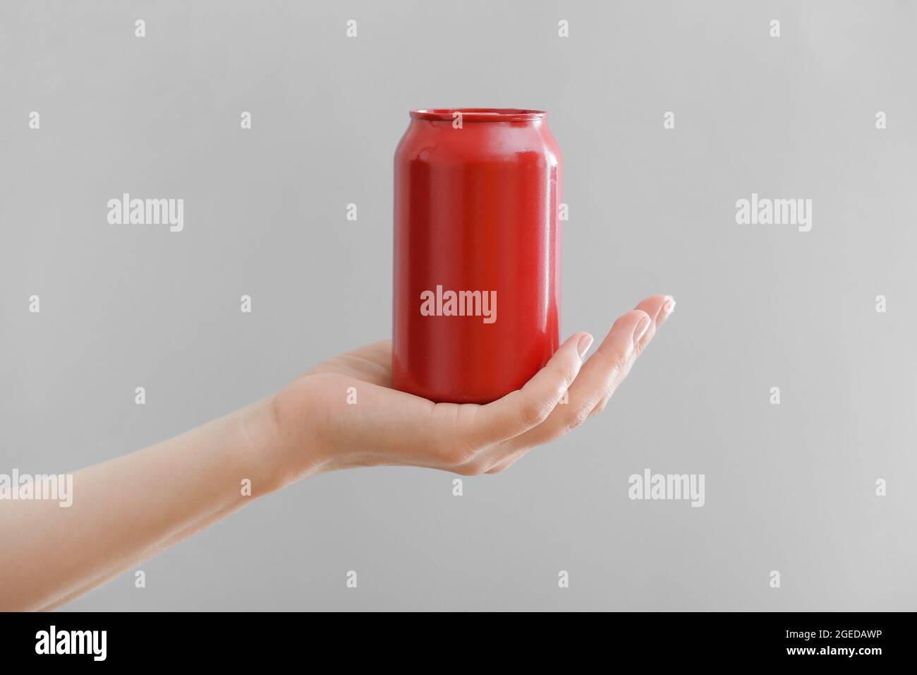 Hand Withe A Can Hand with can of soda on grey background Stock Photo - Alamy
