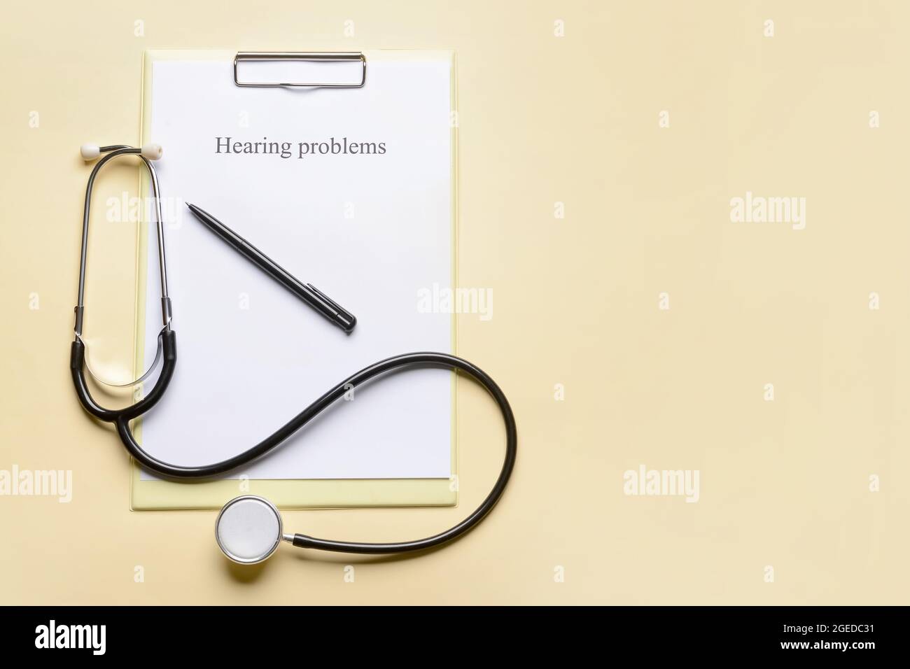 Clipboard with text HEARING PROBLEMS and stethoscope on color background Stock Photo