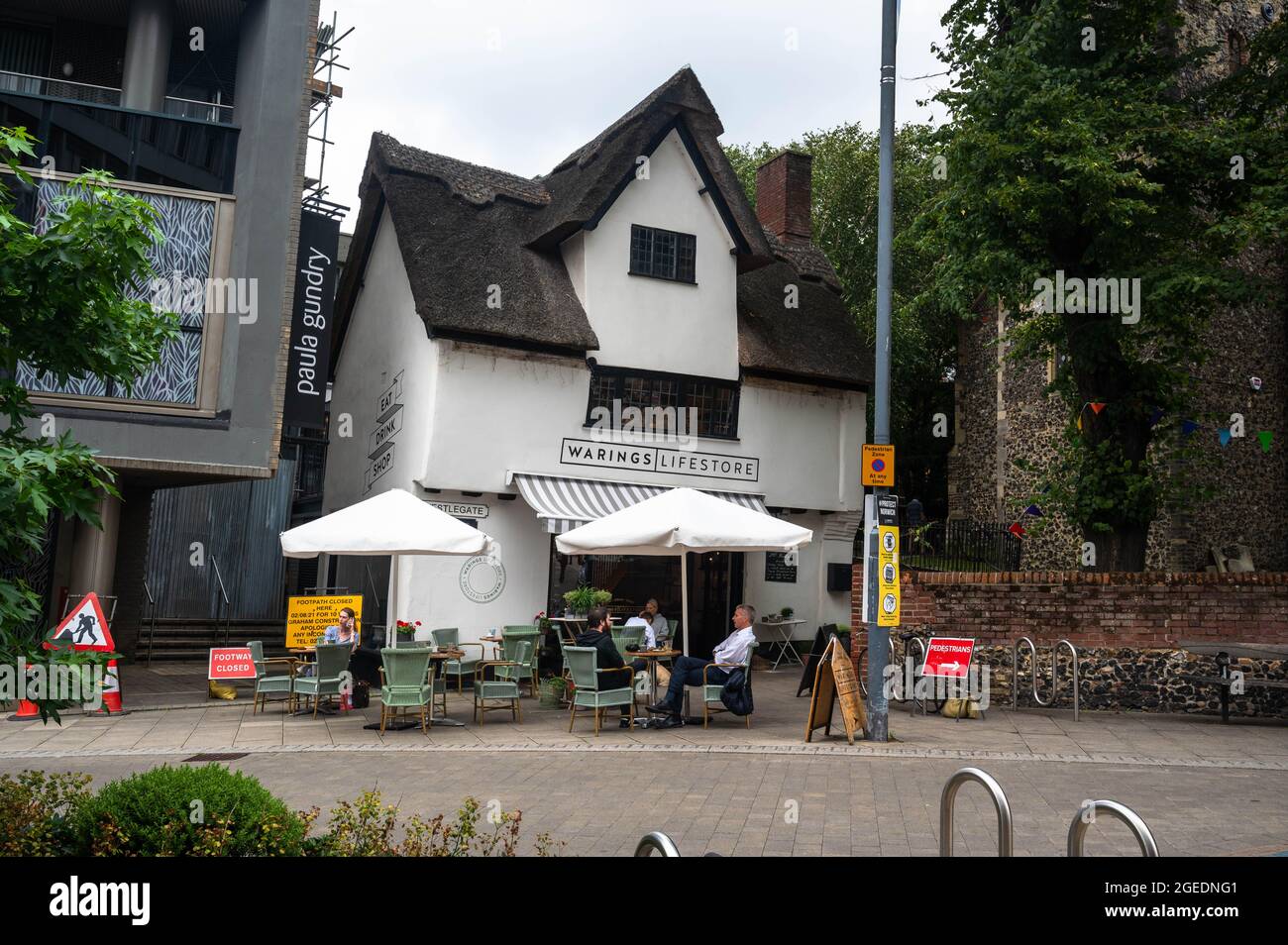 A view of a Thatched building in Westlegate Norwich City centre being used as a Warings home furniture shop as well as a cafe with seating outside. Stock Photo