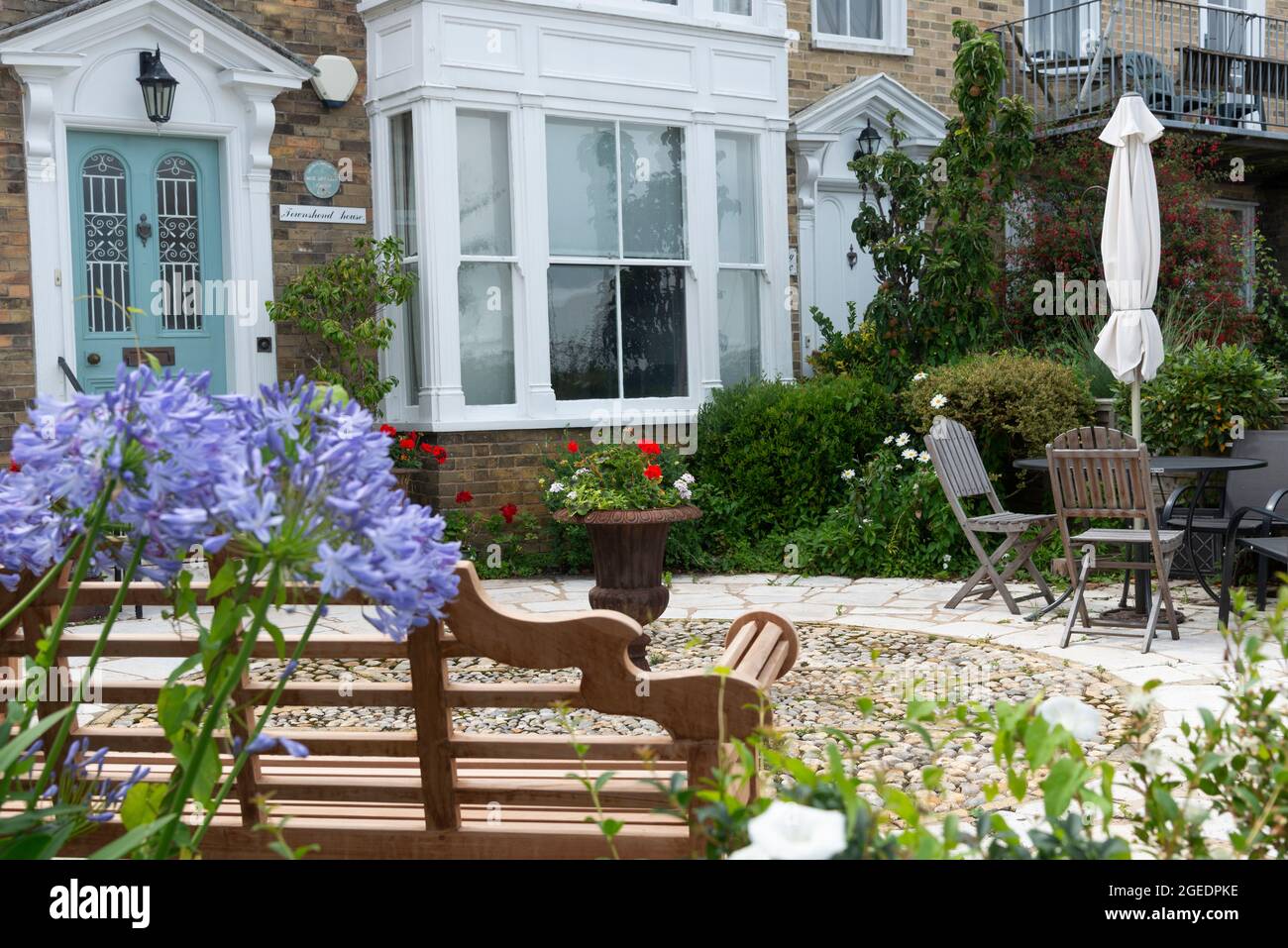 Georgian style house with coastal or seaside garden and agapanthus in flower on the seafront at Cowes, Isle of Wight, England, UK Stock Photo