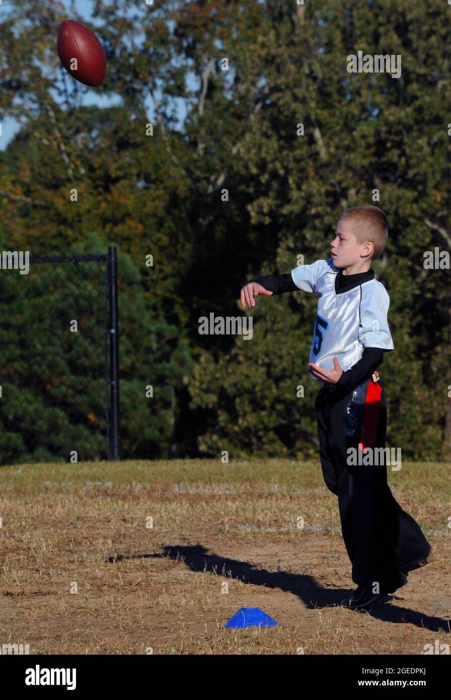 Football is thrown by a boy quarterback during a organized flag