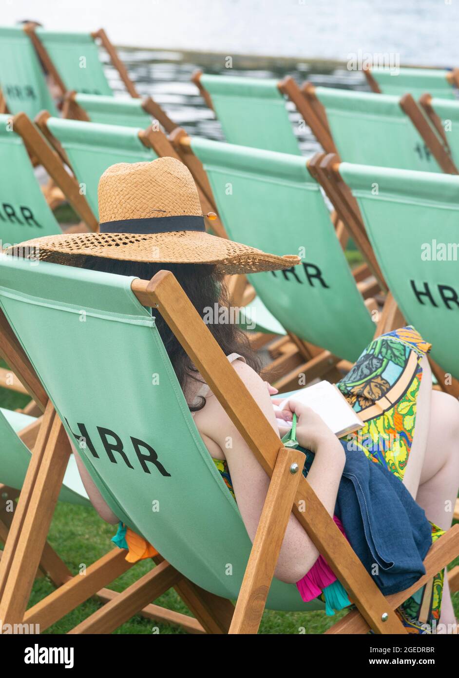 Girl sitting in deckchair in the Steward's Enclosure at Henley Royal Regatta (2021), Henley-on-Thames, Oxfordshire, England, UK Stock Photo