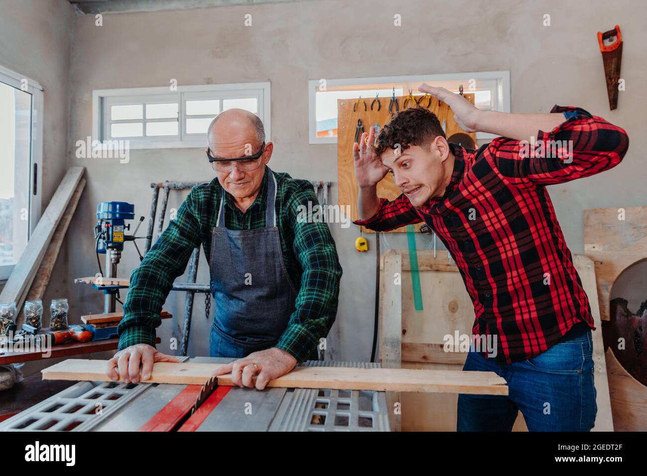 Senior carpenter teaching a younger man how to work Stock Photo