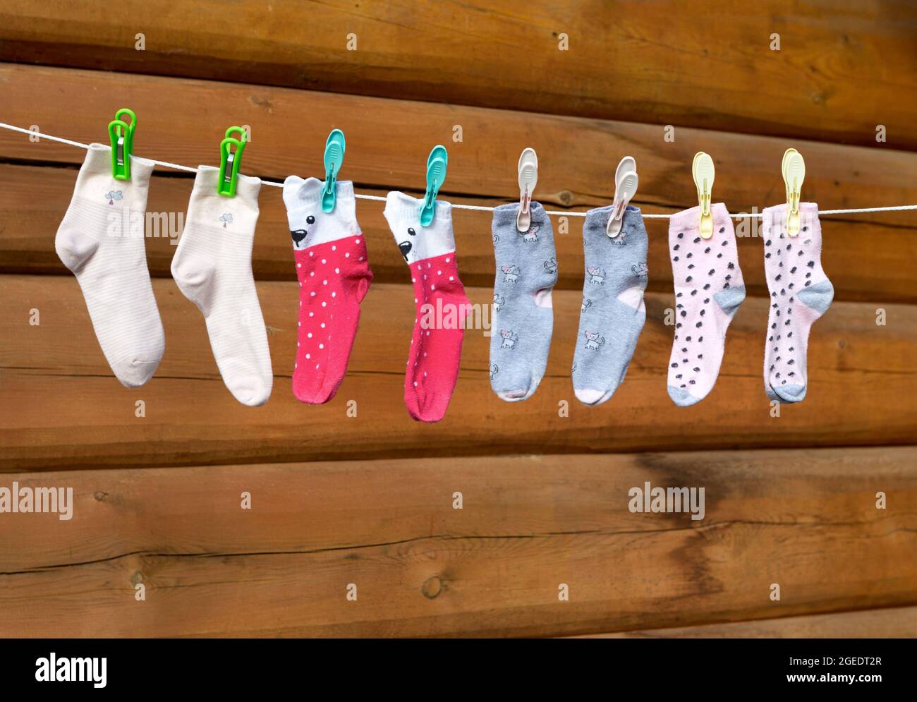 Children socks hanging on a clothesline. Different color socks hang on ...