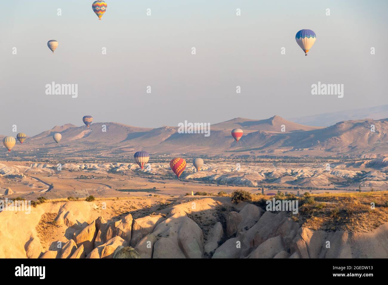 many hot air balloons in the sky over a valley in Cappadocia, Nevsehir, Turkey in a beautiful summer day. sofy focus Stock Photo