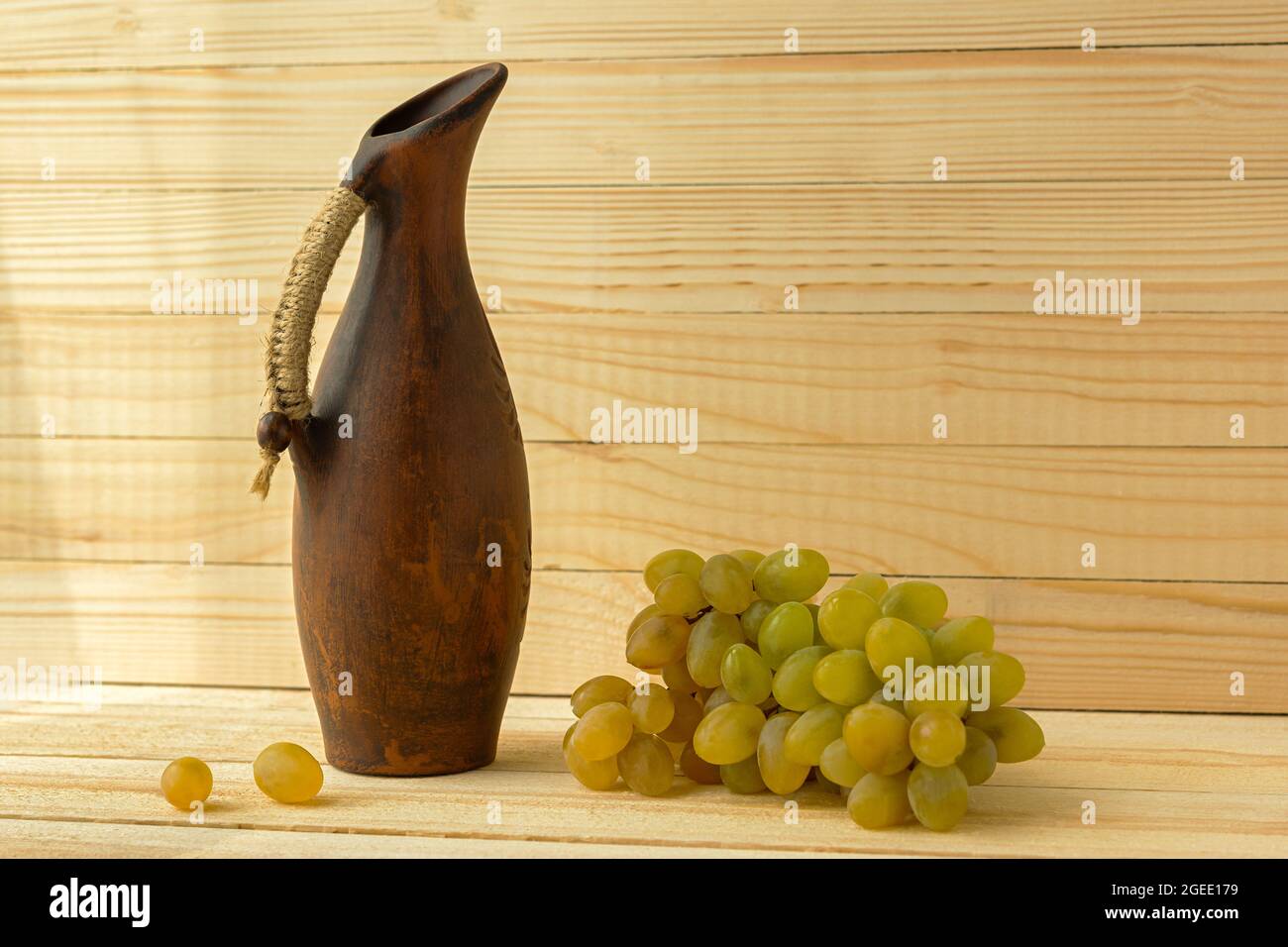 Grape jug on a wooden natural background. Rustic retro style. Antique
