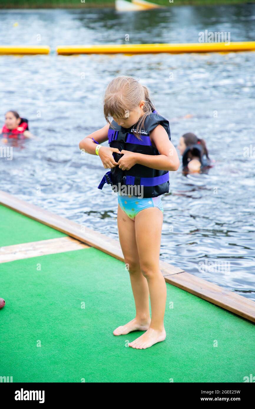 girl unfastens swimming life jacket Stock Photo Alamy