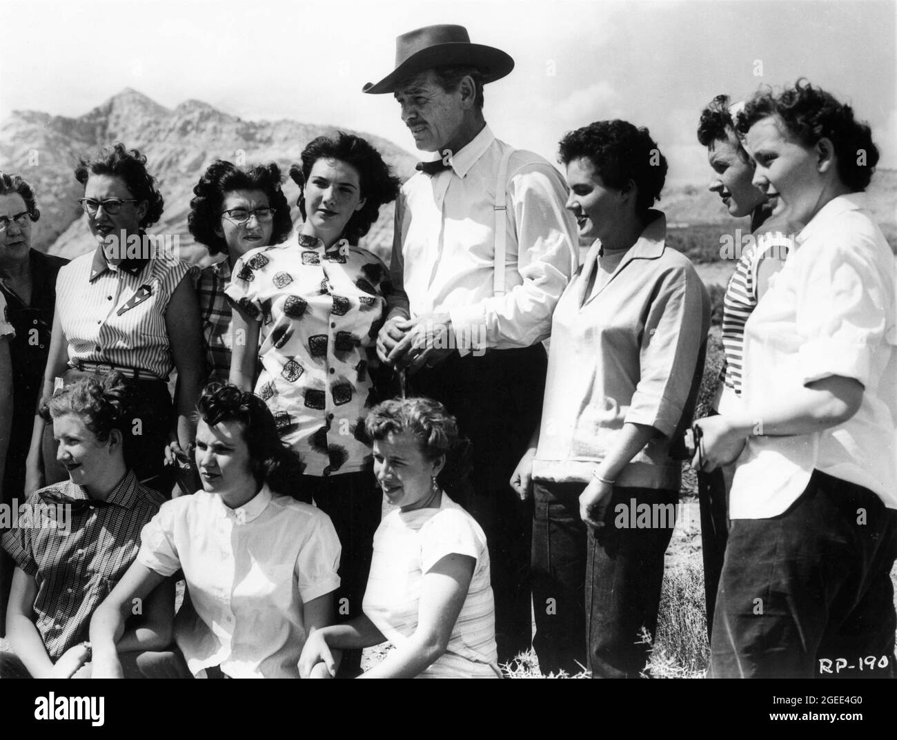 CLARK GABLE poses for a photo with Female Fans on set location candid during filming of THE KING AND FOUR QUEENS 1956 director RAOUL WALSH screenplay Richard Alan Simmons and Margaret Fitts music Alex North Gabco Productions / Russ-Field Productions / United Artists Stock Photo