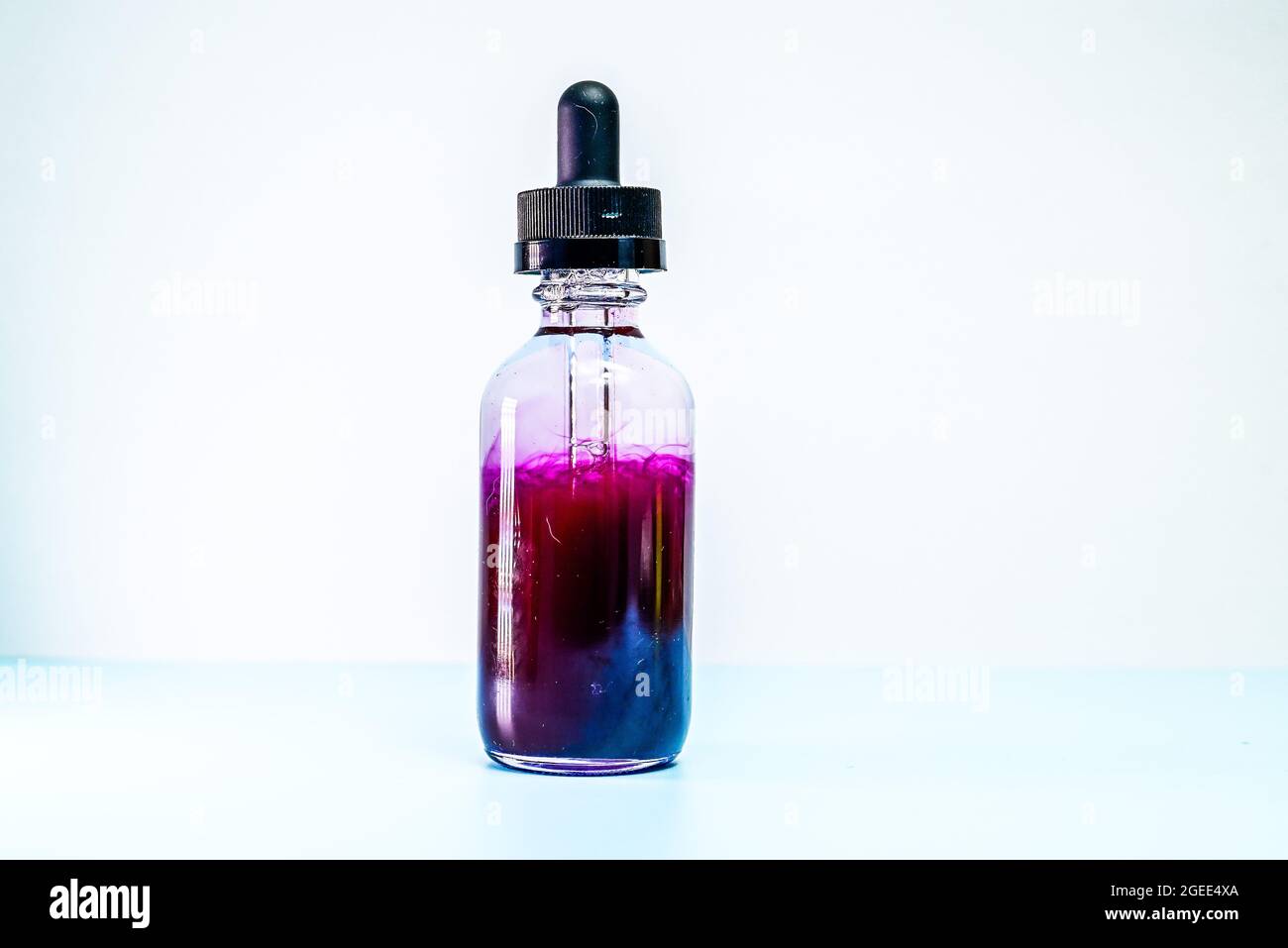 glass flask with purple paint on white background Stock Photo