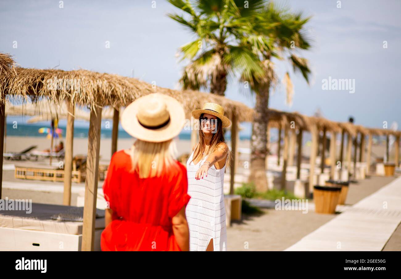 Two pretty young women walking on a beach at summer Stock Photo - Alamy