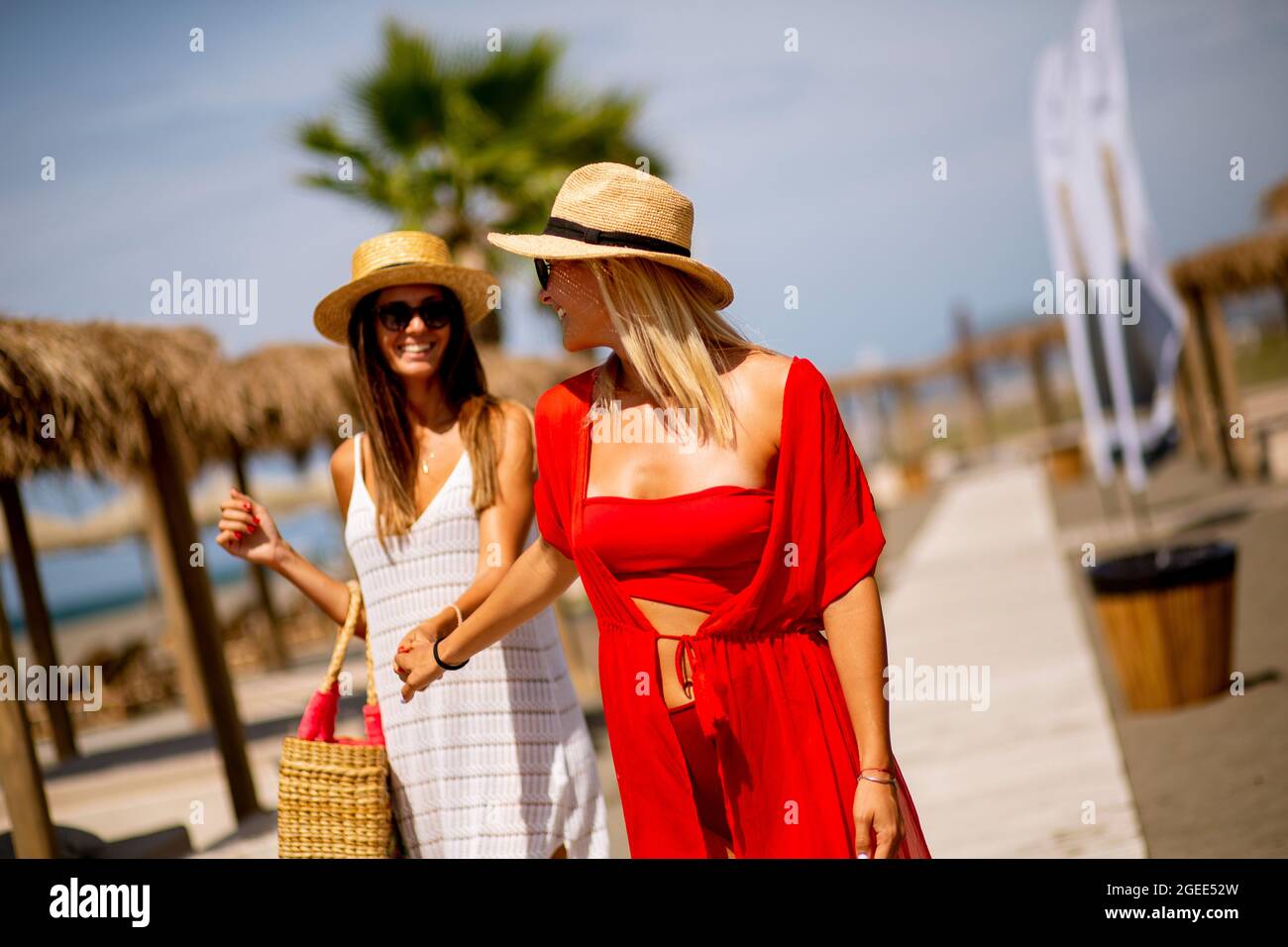 Two pretty young women walking on a beach at summer Stock Photo - Alamy