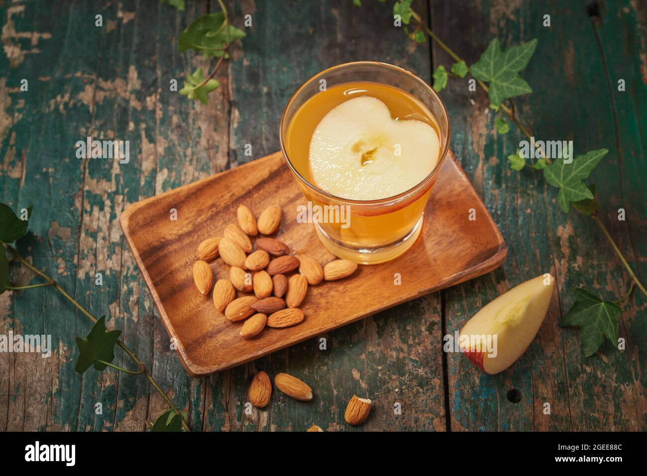 Hot drink of apple tea with cinnamon stick. Hot drink with apples for autumn or winter. Stock Photo