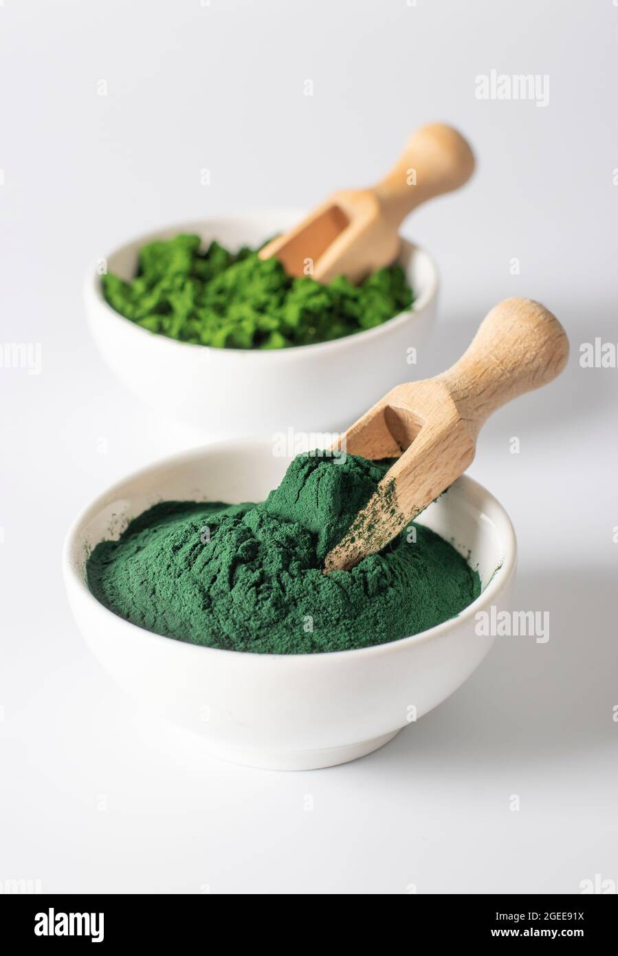 Organic algae chlorella and spirulina in powder form in white bowls