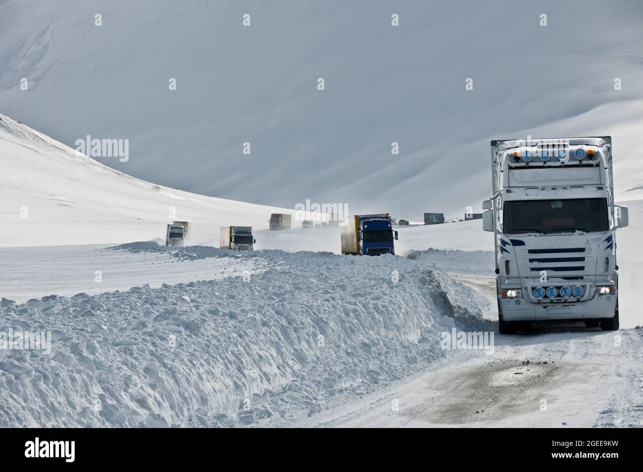 Trucks driving on the snowcovered No 1 road in Iceland, coming down from Oxnadalsheidi mountain pass Stock Photo