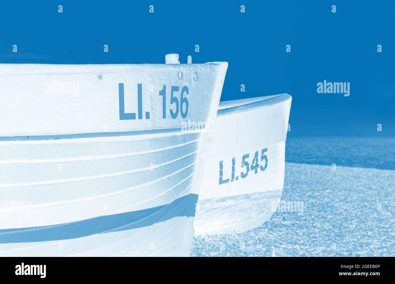 Duocolour image of two small fishing boats on the beach of the UK. Stock Photo