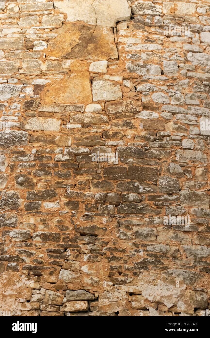 Ancient cracked stone wall made of stacking stone blocks Stock Photo