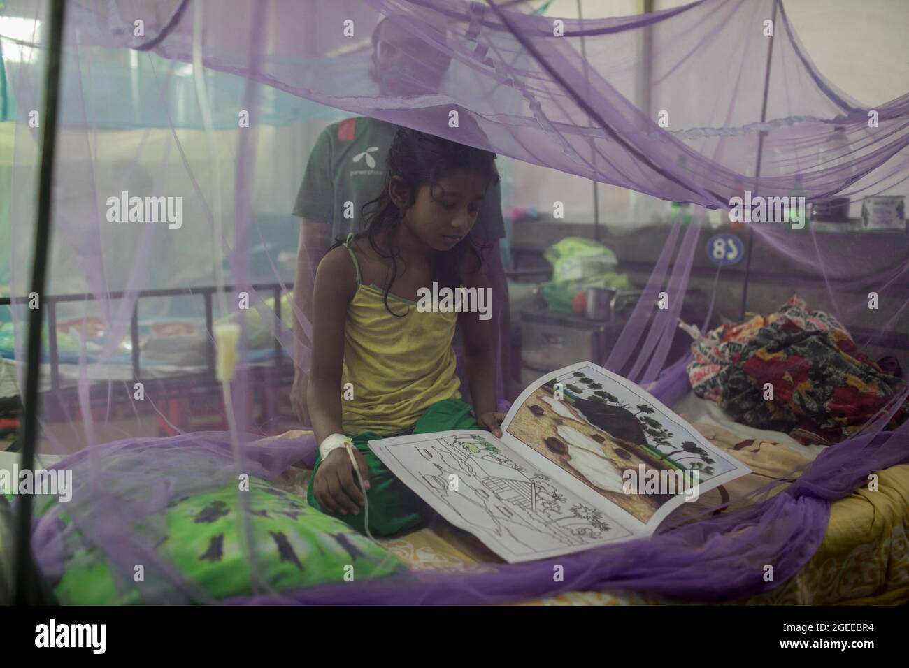 A child seen drawing cartoons inside a mosquito net during daytime at Children's Hospital.With Bangladesh grappling with the Covid-19 pandemic, dengue poses a great threat to the country's children. At present, severe dengue affects most Asian countries and has become a leading cause of hospitalizations and deaths among children as well as adults in these regions, according to WHO. In such dire circumstances, some Dhaka residents are lighting mosquito-repelling incenses even during the day to steer clear of the mosquito-borne viral disease. (Photo by Sazzad Hossain/SOPA Images/Sipa USA) Stock Photo