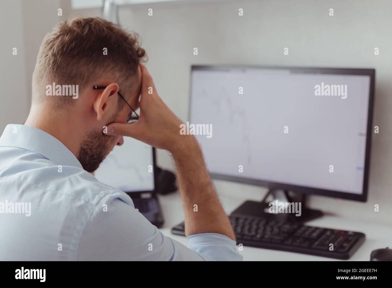 Upset man investor-trader in front of monitors with charts. Stock market correction. Fall of cryptocurrency. Bear market. Forex Stock Photo