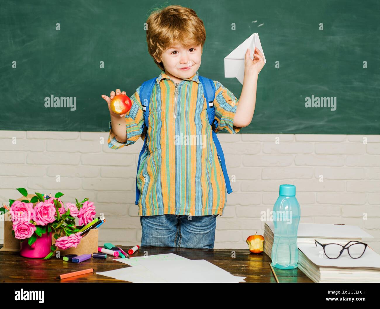 Happy boy with school bag in classroom. Child from elementary school. Education and learning Stock Photo