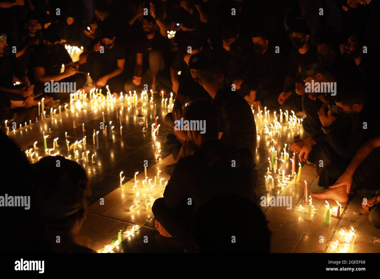 Karbala, Iraq. 19th Aug, 2021. Shiite Muslim worshippers light candles at the Imam Abbas shrine in Iraq's holy city of Karbala on Ashura Day on the 10th of Muharram, the first month of the Islamic calendar. Muharram is considered a month of mourning and remembrance for Shiite Muslims around the world, in which they commemorate the martyrdom of the grandson of the Islamic prophet Mohammad, Husayn ibn Ali, who was killed in the 7th century Battle of Karbala. Credit: Ameer Al Mohammedaw/dpa/Alamy Live News Stock Photo